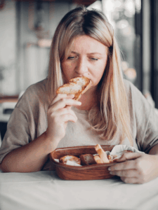 woman emotionally eating bread