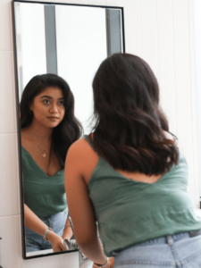 woman looking at her reflection in mirror