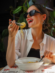 woman in sunglasses enjoying her pasta
